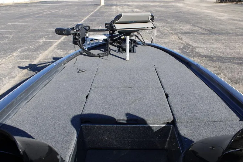 Slide: The Image of 2003 Skeeter ZX250 boat deck with trolling motor in a parking lot. - 16