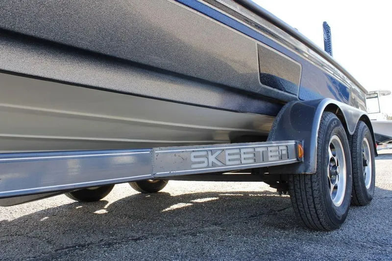 Slide: The Image of 2003 Skeeter ZX250 boat trailer with dual wheels on asphalt surface. - 21
