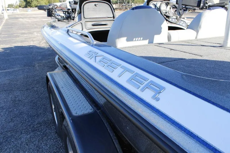 Slide: The Image of 2003 Skeeter ZX250 boat, close-up of logo and seating area, parked on pavement. - 26