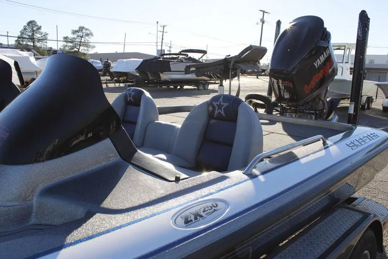 Slide: The Image of 2003 Skeeter ZX250 boat with Yamaha engine, parked outdoors in a marina. - 27