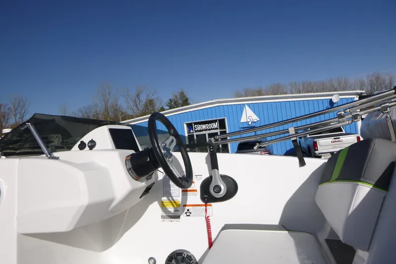 Slide: The Image of 2024 Tahoe T18 boat interior with steering wheel, showroom in background. - 14