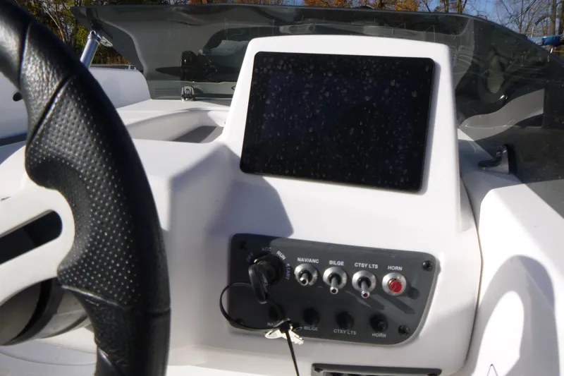 Slide: The Image of 2024 Tahoe T18 boat dashboard with steering wheel and control panel. - 16