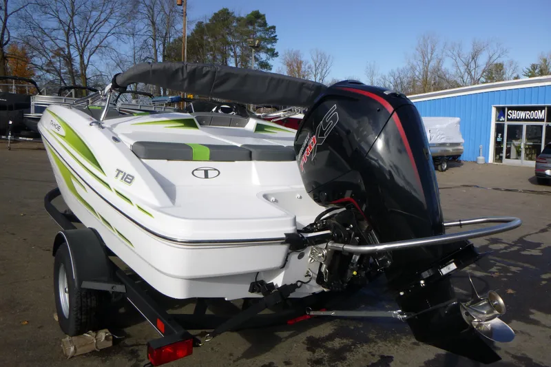Slide: The Image of 2024 Tahoe T18 boat with outboard motor, parked near a showroom. - 4