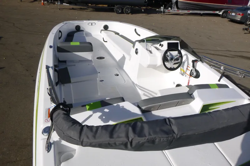 Slide: The Image of 2024 Tahoe T18 boat interior with modern seating and steering wheel, parked on a lot. - 7