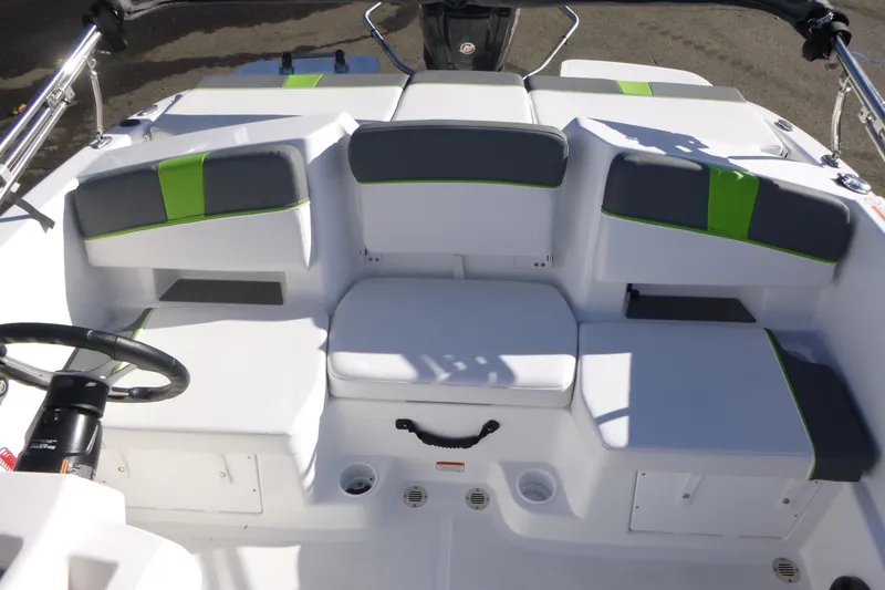 Slide: The Image of 2024 Tahoe T18 boat interior with white and green seating, steering wheel visible. - 9