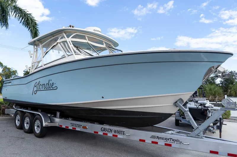 The Image of 2024 Grady-White Freedom 307 boat on trailer, light blue hull, parked outdoors. - 0