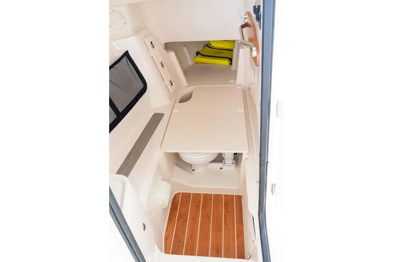 Slide: The Image of 2024 Grady-White Freedom 307 cabin interior with wooden flooring and compact amenities. - 19