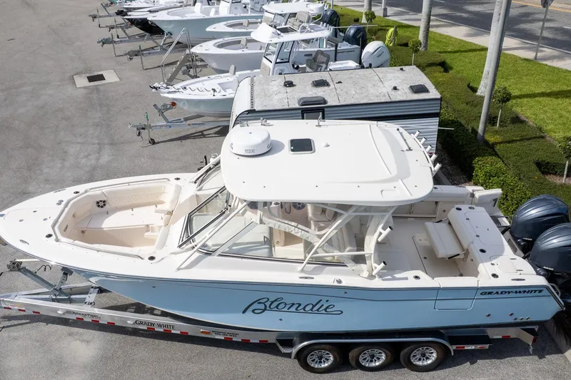 Slide: The Image of 2024 Grady-White Freedom 307 boat on trailer, parked in marina lot. - 2