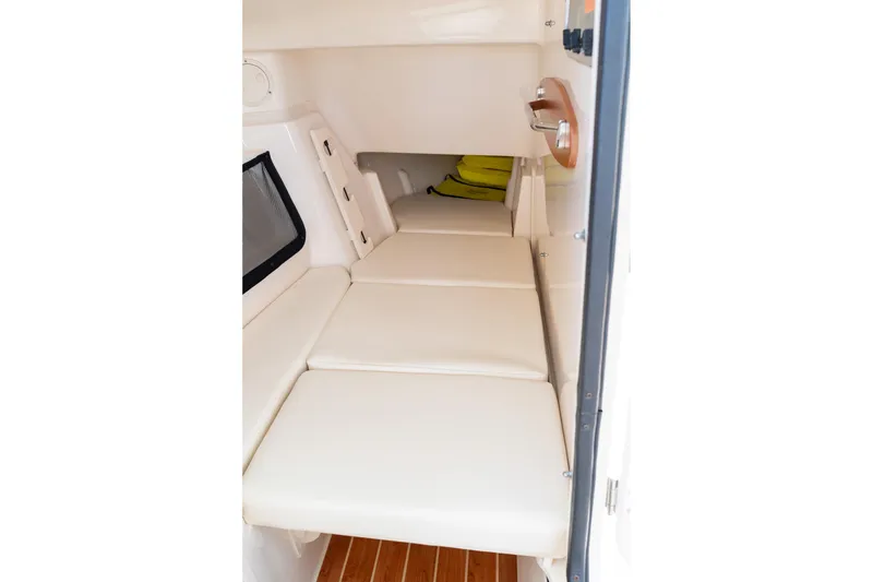 Slide: The Image of 2024 Grady-White Freedom 307 cabin interior with cushioned seating and wooden flooring. - 23