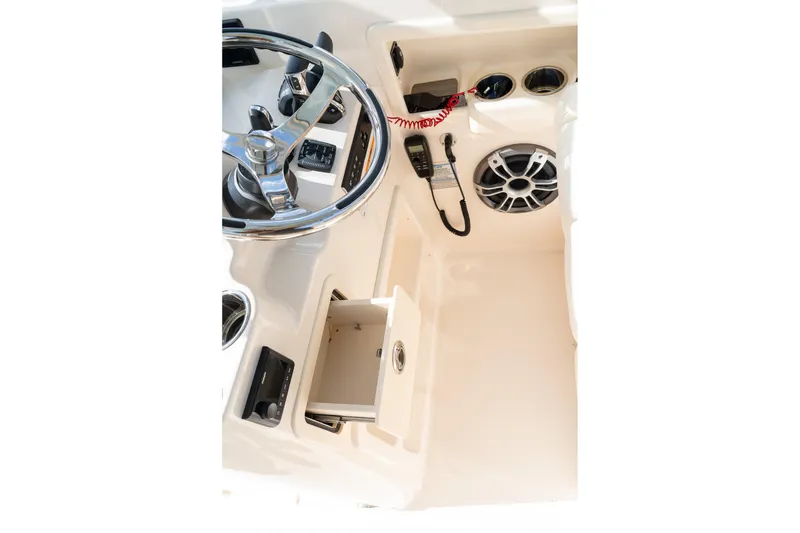 Slide: The Image of 2024 Grady-White Freedom 307 helm with steering wheel, controls, and storage compartment. - 24