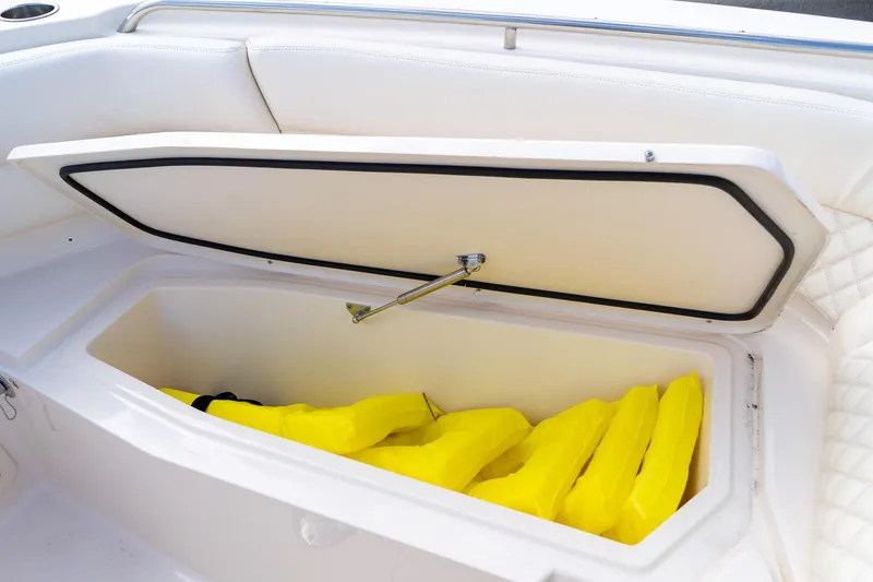 Slide: The Image of Storage compartment with yellow life jackets on a 2024 Grady-White Freedom 307 boat. - 32