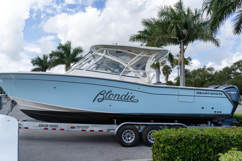 Slide: The Image of 2024 Grady-White Freedom 307 boat on trailer, palm trees in background. - 4