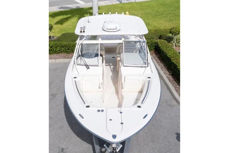 Slide: The Image of 2024 Grady-White Freedom 307 boat, aerial view, docked on pavement with green grass background. - 7