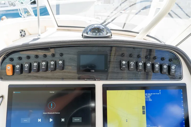 Slide: The Image of 2024 Grady-White Freedom 307 dashboard with navigation and control panels. - 9