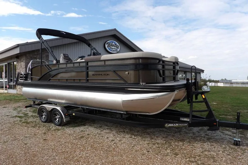 The Image of 2026 Bennington S Swingback 22 SSB pontoon boat on trailer, parked outside marine center. - 1