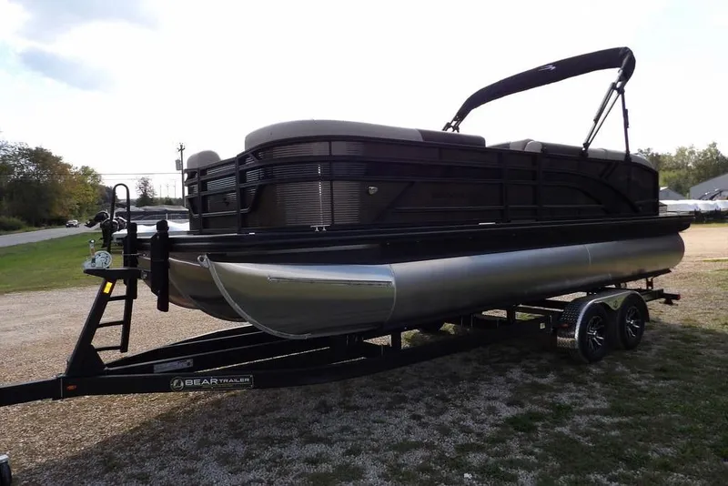 Slide: The Image of 2026 Bennington S Swingback 22 SSB pontoon boat on trailer, parked outdoors. - 2