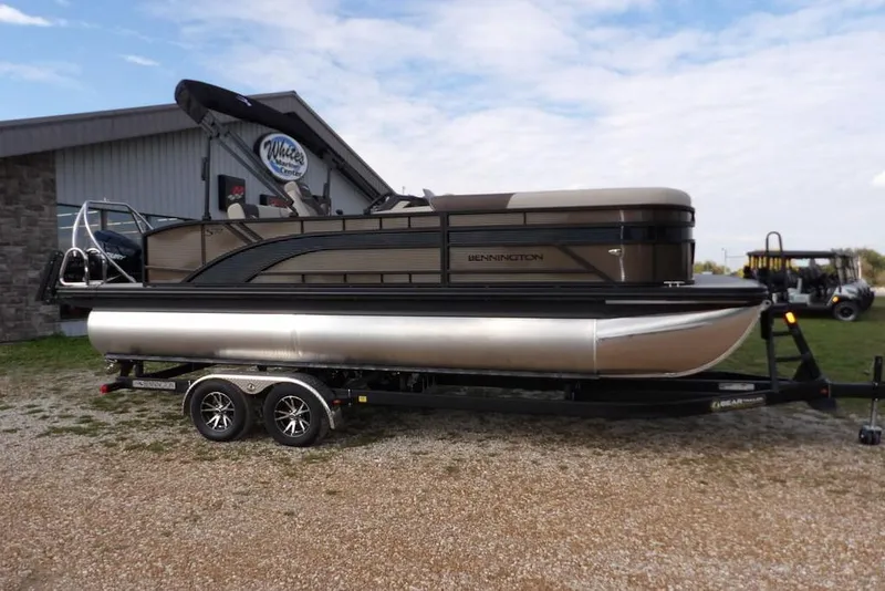 Slide: The Image of 2026 Bennington S Swingback 22 SSB pontoon boat on trailer, parked outdoors. - 3
