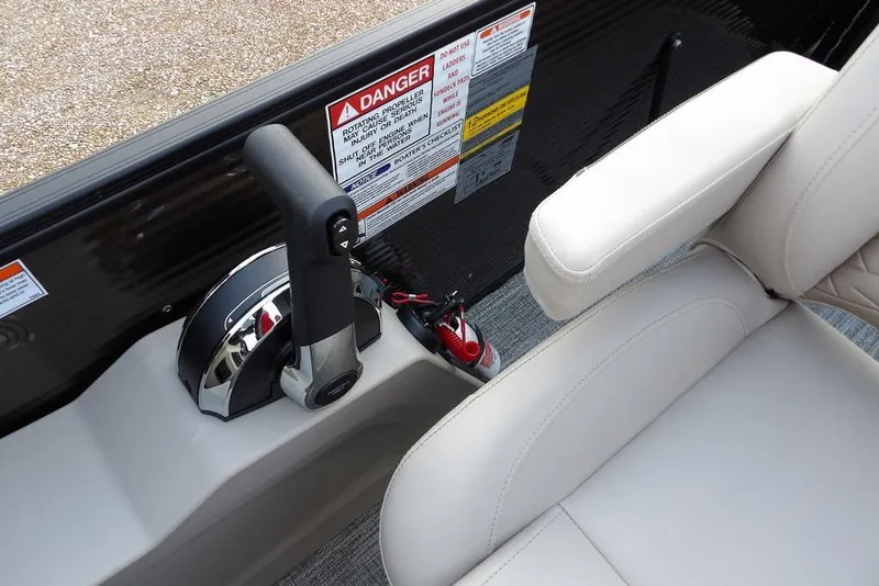 Slide: The Image of 2026 Bennington S Swingback 22 SSB boat controls and seating area with safety labels. - 31