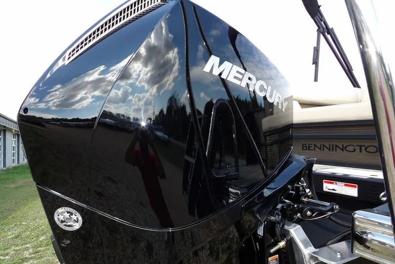 Slide: The Image of 2026 Bennington S Swingback 22 SSB with Mercury engine, reflecting sky and clouds. - 53