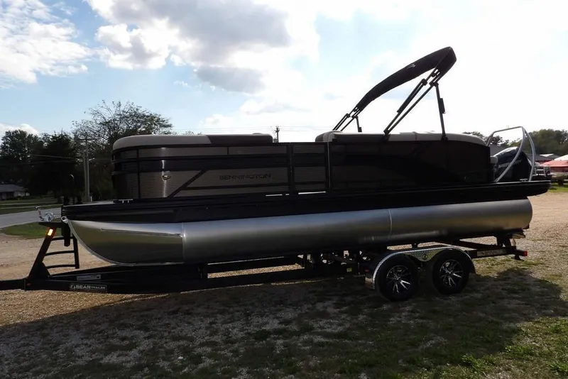 Slide: The Image of 2026 Bennington S Swingback 22 SSB pontoon boat on trailer, parked outdoors. - 8