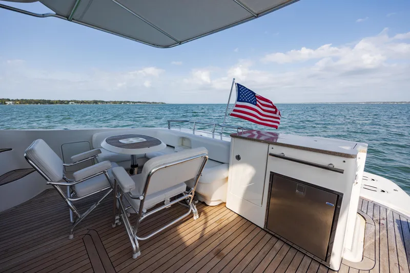 Slide: The Image of 2008 Sea Ray 52 Sedan Bridge yacht deck with seating and American flag. - 23