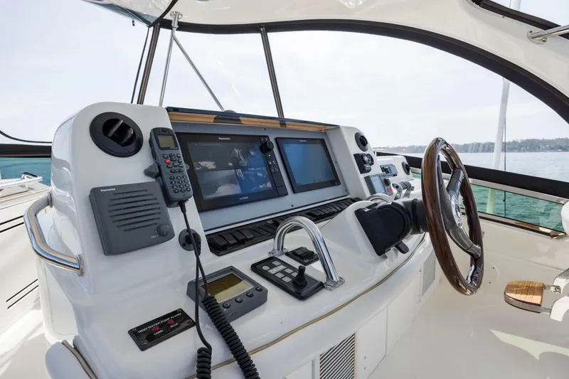 Slide: The Image of 2008 Sea Ray 52 Sedan Bridge helm with advanced navigation equipment and wooden steering wheel. - 38