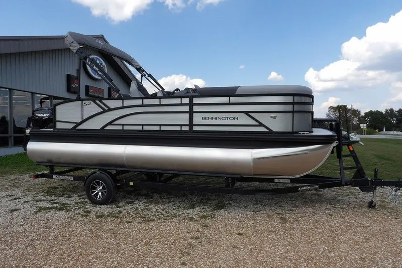 The Image of 2026 Bennington S Swingback 21 SSB pontoon boat on trailer, parked outdoors. - 1