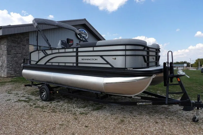 Slide: The Image of 2026 Bennington S Swingback 21 SSB pontoon boat on trailer, parked outdoors. - 2