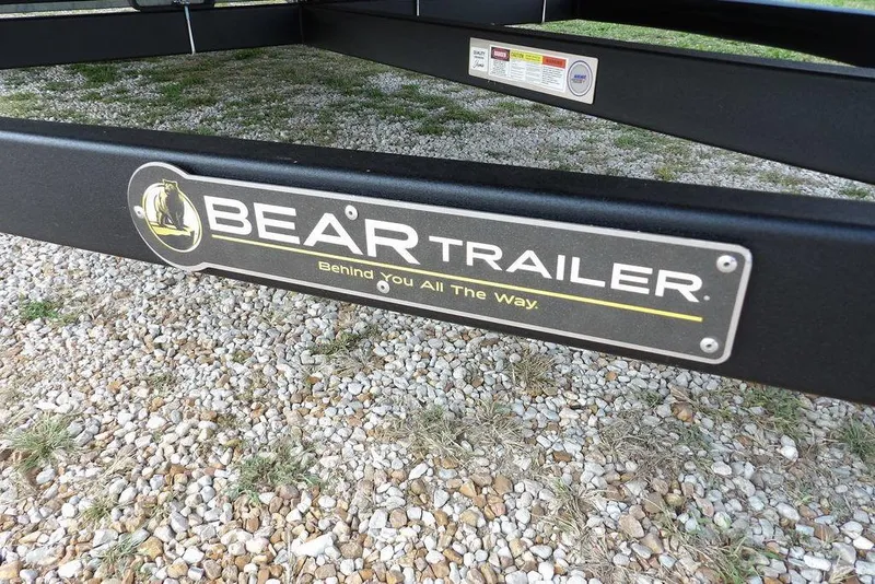 Slide: The Image of Bear Trailer logo on a gravel surface, supporting a 2026 Bennington S Swingback 21 SSB. - 43