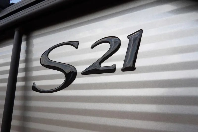 Slide: The Image of Close-up of 2026 Bennington S Swingback 21 SSB model emblem on metallic surface. - 46