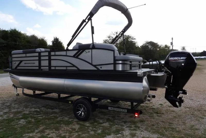 Slide: The Image of 2026 Bennington S Swingback 21 SSB pontoon boat with Mercury outboard engine on trailer. - 5