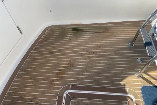 Slide: The Image of Teak deck of a 2006 Nordic Tug 42 with metal steps and slight discoloration. - 15