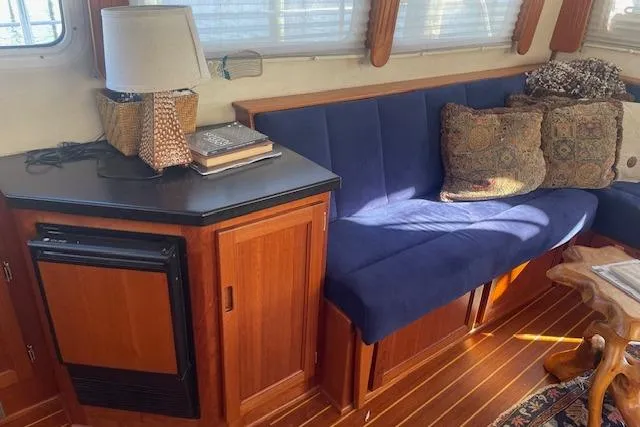 Slide: The Image of Interior of 2006 Nordic Tug 42 with blue seating, wooden cabinetry, and decorative pillows. - 23