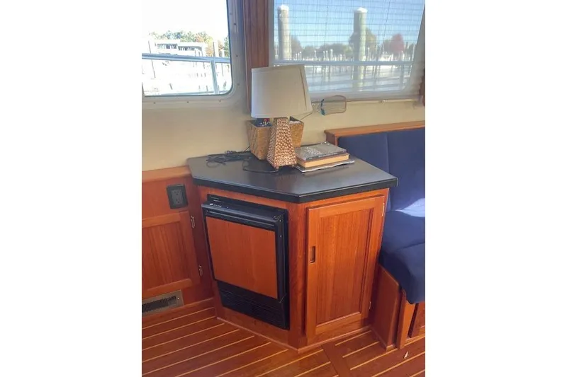 Slide: The Image of Cozy interior of 2006 Nordic Tug 42 with wooden cabinetry and a small lamp. - 24