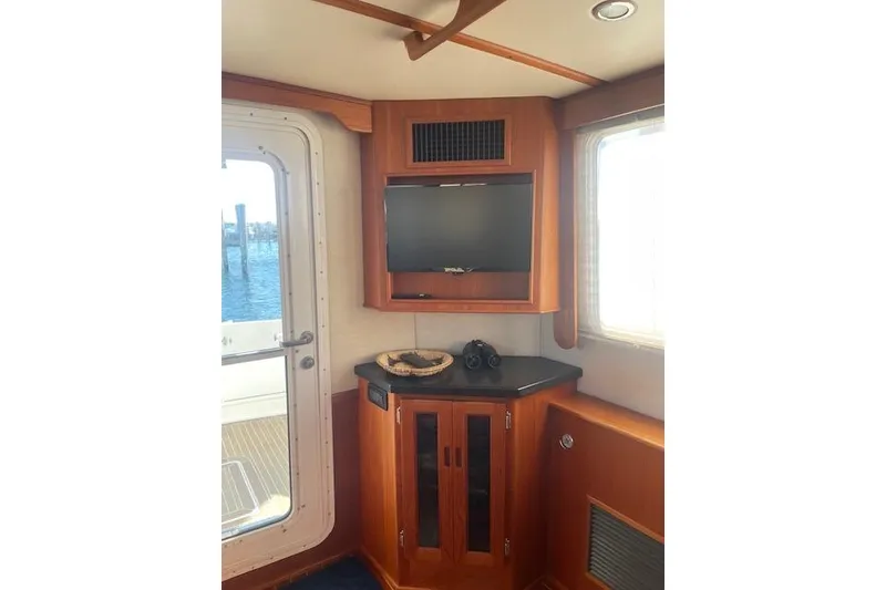 Slide: The Image of Interior of 2006 Nordic Tug 42 with TV, cabinet, and window view. - 27
