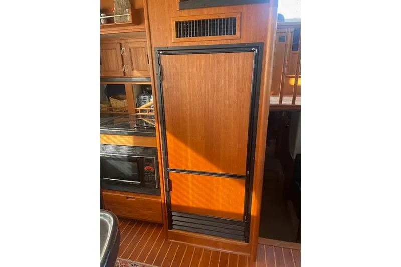 Slide: The Image of Interior of 2006 Nordic Tug 42, featuring wooden cabinetry and built-in appliances. - 29