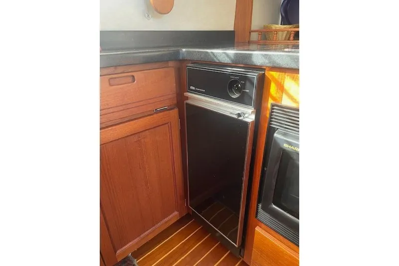 Slide: The Image of 2006 Nordic Tug 42 interior kitchen with wooden cabinetry and compact appliances. - 30
