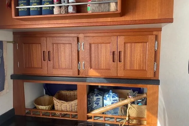 Slide: The Image of Wooden cabinetry in a 2006 Nordic Tug 42, featuring storage baskets and pantry items. - 31