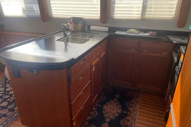 Slide: The Image of 2006 Nordic Tug 42 kitchen with wooden cabinets, black countertop, and stainless steel sink. - 33