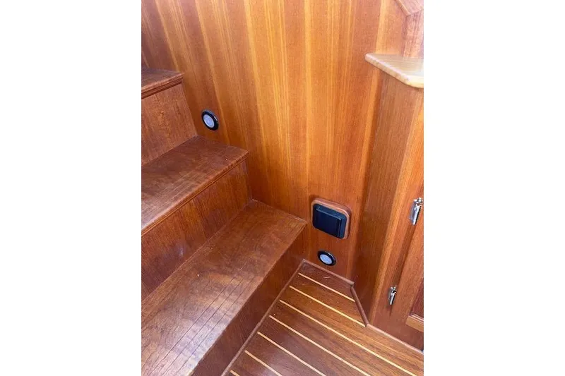 Slide: The Image of Wooden interior stairs of a 2006 Nordic Tug 42 boat, featuring built-in lighting. - 34