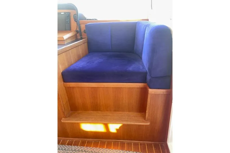 Slide: The Image of Blue cushioned seating on 2006 Nordic Tug 42 boat with wooden finish. - 36