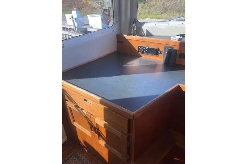 Slide: The Image of 2006 Nordic Tug 42 interior with wooden cabinetry and navigation equipment. - 41
