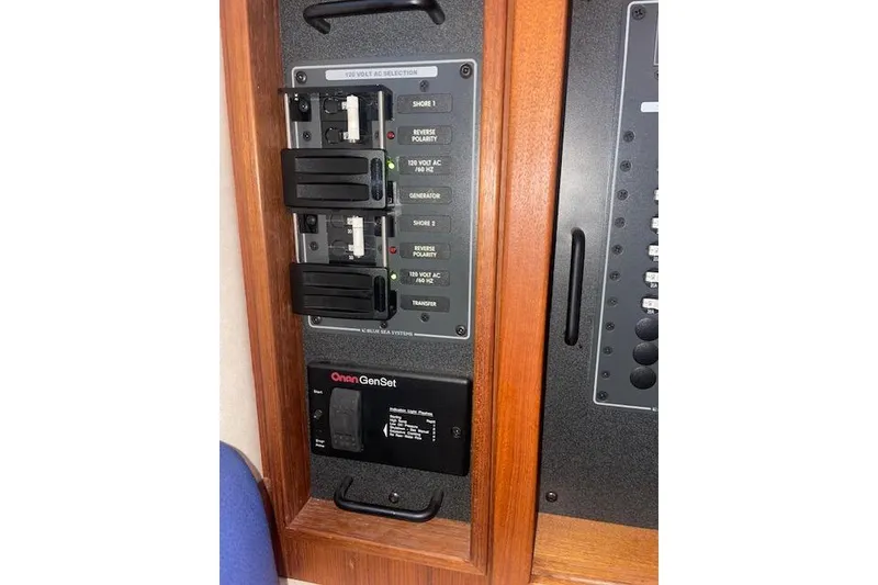 Slide: The Image of Electrical panel on a 2006 Nordic Tug 42 boat, featuring Onan GenSet controls. - 46