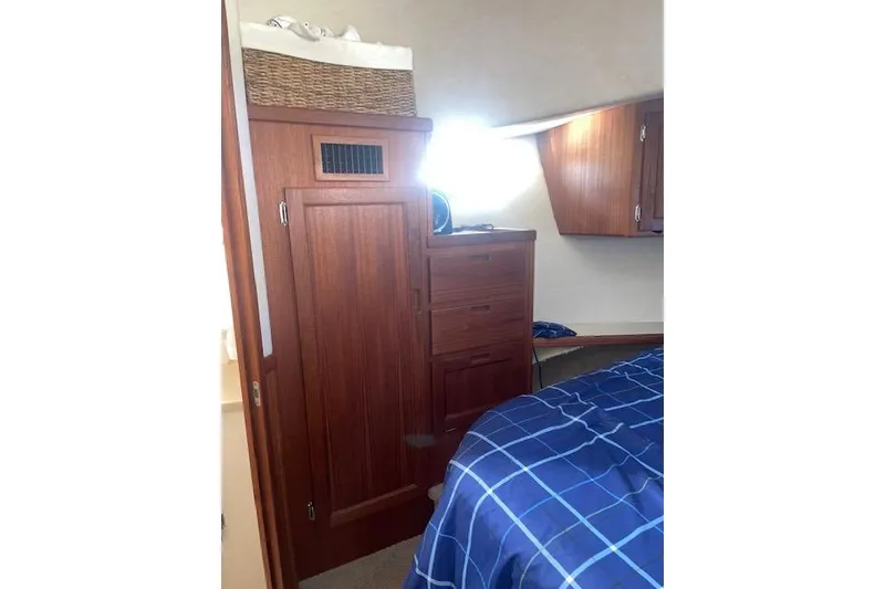 Slide: The Image of Cozy cabin interior of 2006 Nordic Tug 42 with wooden cabinetry and blue bedding. - 53