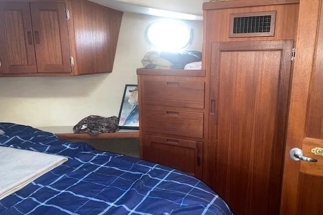 Slide: The Image of Cozy cabin interior of 2006 Nordic Tug 42 with wooden cabinetry and blue bedding. - 54
