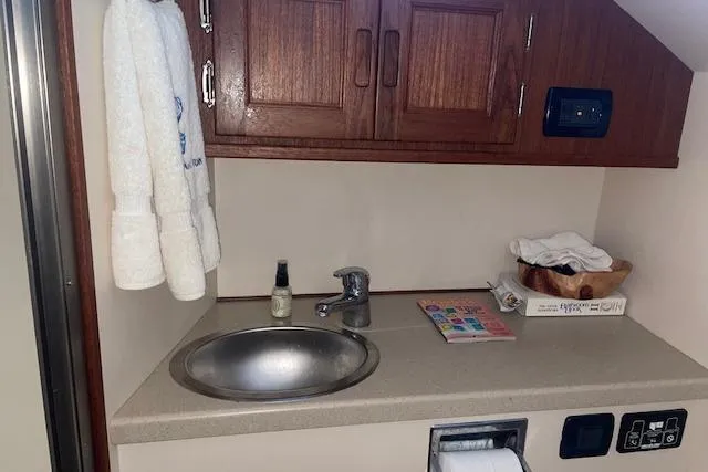 Slide: The Image of 2006 Nordic Tug 42 bathroom with sink, wooden cabinets, and toiletries. - 56