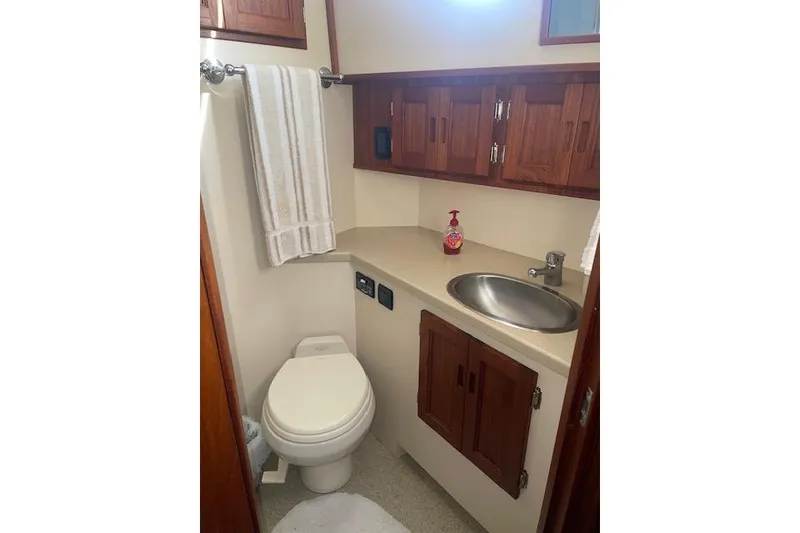 Slide: The Image of Bathroom interior of 2006 Nordic Tug 42 with sink, toilet, and wooden cabinets. - 58