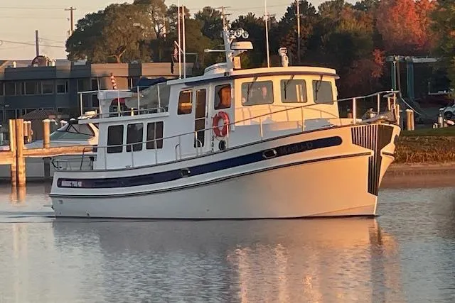 Slide: The Image of 2006 Nordic Tug 42 boat docked in calm waters at sunset. - 8