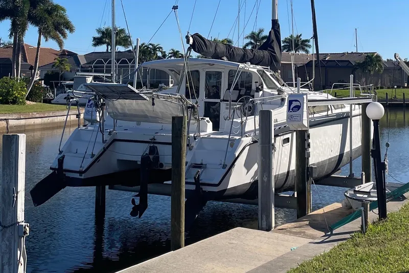 Slide: The Image of Sailboat PCI 105 MC 2009 docked in a sunny marina with palm trees. - 2