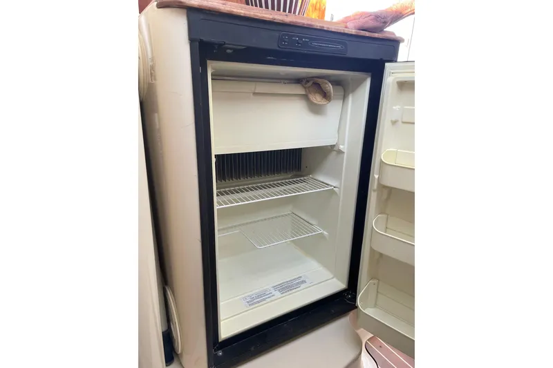 Slide: The Image of Empty PCI 105 MC refrigerator, 2009 model, with open door and visible shelves. - 20